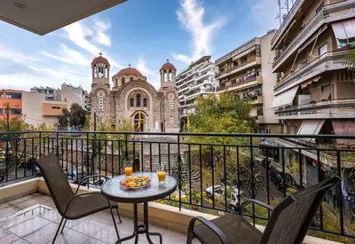 a balcony with a table and chairs and a building at Athens Luxury with Amazing View in Athens
