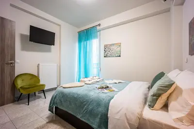 a bedroom with a bed and a chair and a television at Athens Luxury with Amazing View in Athens