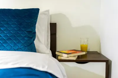a bed with a blue pillow and a table with a glass of orange juice at Athens Luxury with Amazing View in Athens