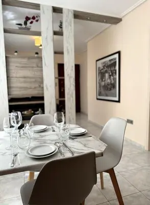 a dining room table with chairs and wine glasses at Hera House Entire APT next to the Acropolis in Athens