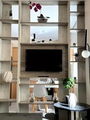 a living room with a television in a wall with shelves at Hera House Entire APT next to the Acropolis in Athens