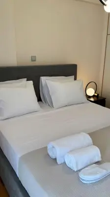 a white bed with two folded towels on it at Hera House Entire APT next to the Acropolis in Athens