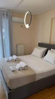 a bedroom with a bed with towels and a mirror at Hera House Entire APT next to the Acropolis in Athens