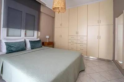 a bedroom with a large bed with blue pillows at Luxury apt near the airport N2 in Spáta
