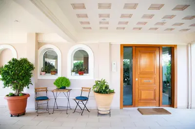 a front door of a house with chairs and plants at Luxury apt near the airport N2 in Spáta