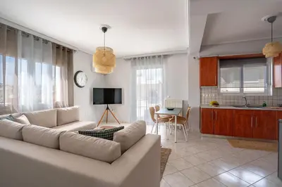 a living room with a couch and a kitchen at Luxury apt near the airport N2 in Spáta