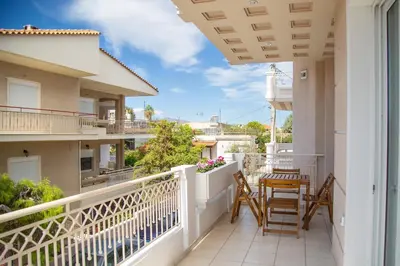 a balcony with chairs and a table on it at Luxury apt near the airport N2 in Spáta