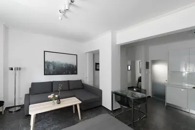 a living room with a black couch and a table at Central Studio in Athens lower Pangrati 650m Evangelismo Metro in Athens