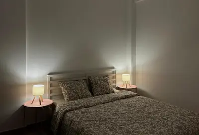 a bedroom with a bed and two lamps on tables at Embassy studio in Athens