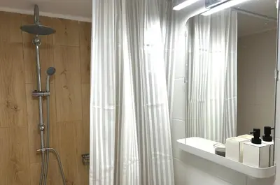 a bathroom with a shower curtain and a mirror at Embassy studio in Athens