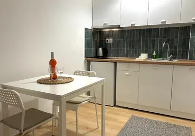 a kitchen with a white table with a bottle of wine on it at Embassy studio in Athens