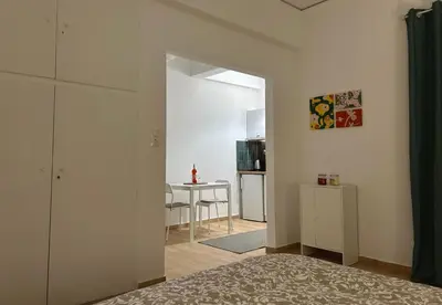 a bedroom with a door open to a kitchen with a table at Embassy studio in Athens