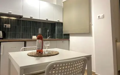 a bottle of wine sitting on a table with a glass at Embassy studio in Athens