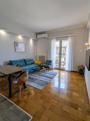 a living room with a blue couch and a table at Cozy Corner, One-Bedroom Flat in Athens