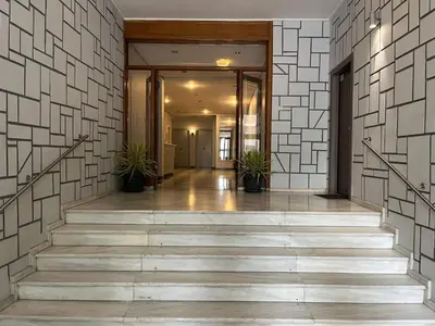 a hallway of a building with stairs and potted plants at Cozy Corner, One-Bedroom Flat in Athens
