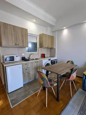 a kitchen with a table and chairs in a room at Cozy Corner, One-Bedroom Flat in Athens