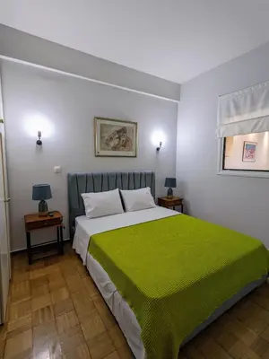 a bedroom with a large bed with a green blanket at Cozy Corner, One-Bedroom Flat in Athens