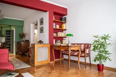 a living room with a desk and a red wall at Casa al Museo in Athens