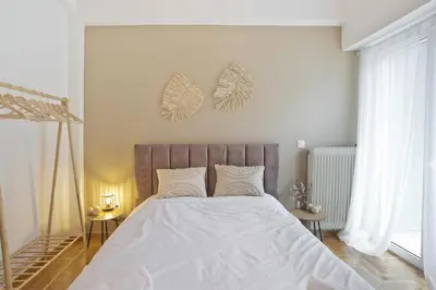 a white bedroom with a large bed with white sheets at Pinelopi Spotless 2 BR Renovated Apt Athens Center in Athens