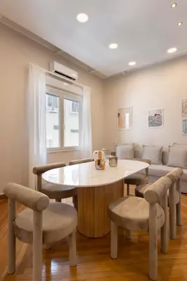 a living room with a table and chairs and a couch at Kallirois Avenue House 7ppl 2BR Acropolis Metro Plaka 300m in Athens
