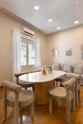a living room with a table and chairs and a couch at Kallirois Avenue House 7ppl 2BR Acropolis Metro Plaka 300m in Athens