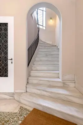 a staircase in a home with white walls and a door at Kallirois Avenue House 7ppl 2BR Acropolis Metro Plaka 300m in Athens