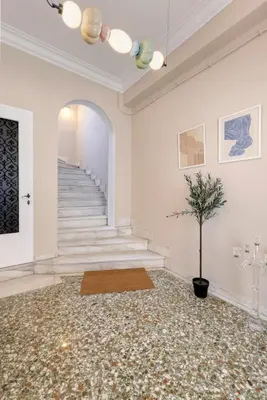 a hallway with a staircase and a potted plant at Kallirois Avenue House 7ppl 2BR Acropolis Metro Plaka 300m in Athens