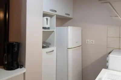 a kitchen with a white refrigerator in a kitchen at Penthouse with Acropolis view in Attiki Metro in Athens