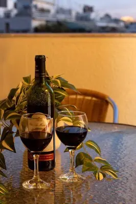 a bottle of wine and two glasses on a table at Penthouse with Acropolis view in Attiki Metro in Athens