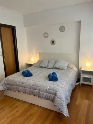 a bedroom with a bed with two blue pillows on it at Enjoy The Athens Riviera! in Athens