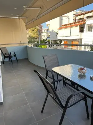 a patio with a table and chairs on a balcony at Enjoy The Athens Riviera! in Athens