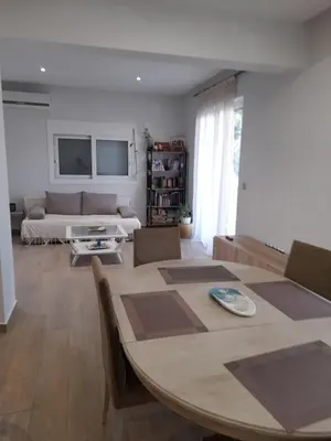 a living room with a table and a couch at Al Fresco Voula Apartment in Athens
