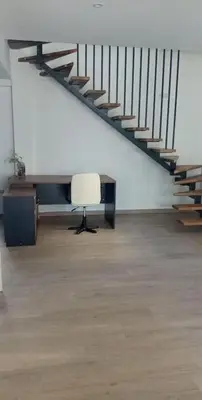 a room with a desk and a chair and stairs at Al Fresco Voula Apartment in Athens