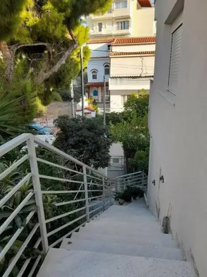 a stairway leading up to a building with a fence at Al Fresco Voula Apartment in Athens