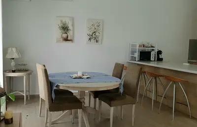 a table and chairs in a kitchen with a counter at Al Fresco Voula Apartment in Athens