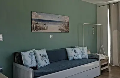 a living room with a blue couch with pillows at Al Fresco Voula Apartment in Athens