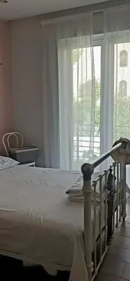 a bedroom with a white bed and a large window at Al Fresco Voula Apartment in Athens