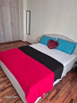 a bedroom with a large bed with red and blue pillows at Lavender-Dalia cosy apartment center of Athens in Athens
