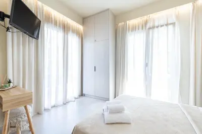 a bedroom with a bed and a desk and windows at AVM Suites - Athens Thissio Center in Athens