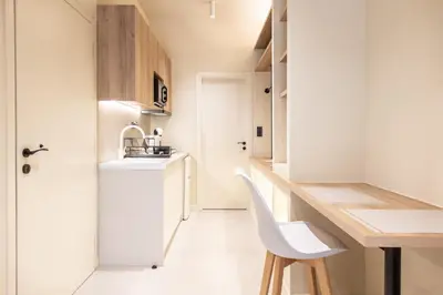a small kitchen with a desk and a white chair at AVM Suites - Athens Thissio Center in Athens