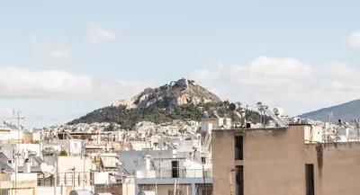 a view of a city with a mountain in the background at AVM Suites - Athens Thissio Center in Athens