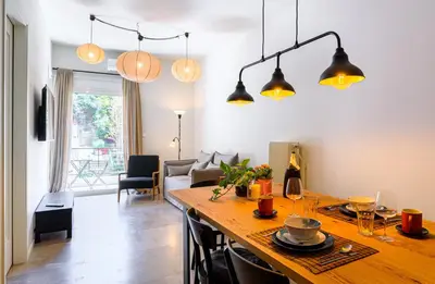 a kitchen and living room with a large wooden table at 2 BD Lycabettus Stylish Apartment by Live&Travel in Athens