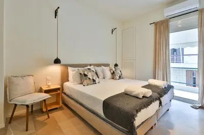 a bedroom with a bed and a chair and a window at 2 BD Lycabettus Stylish Apartment by Live&Travel in Athens