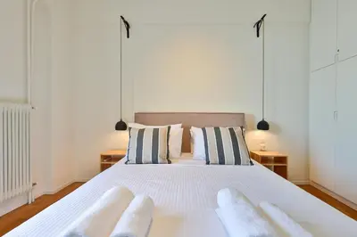 a bedroom with a large white bed with two pillows at 2 BD Lycabettus Stylish Apartment by Live&Travel in Athens