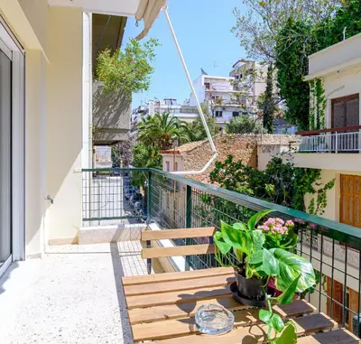 a balcony with a wooden bench and plants on it at 2 BD Lycabettus Stylish Apartment by Live&Travel in Athens
