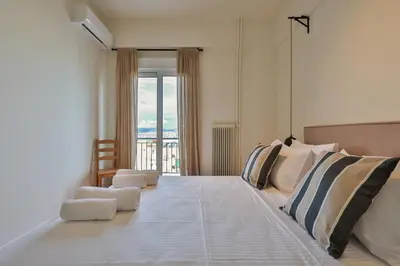 a bedroom with a large bed with a large window at 2 BD Lycabettus Stylish Apartment by Live&Travel in Athens