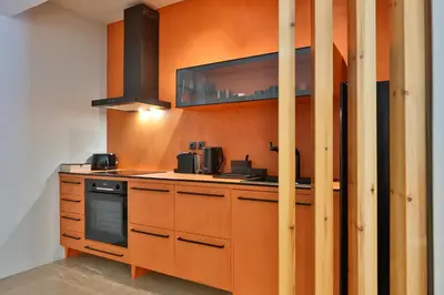 a kitchen with orange walls and a stove top oven at 2 BD Lycabettus Stylish Apartment by Live&Travel in Athens