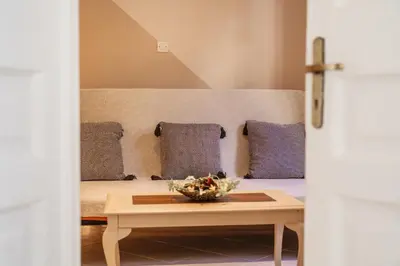 a room with a bed with a table and pillows at 1 BD Lycabettus Neoclassic House by Live&Travel in Athens