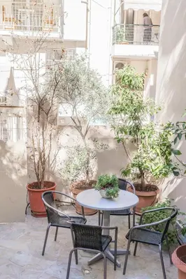 a patio with a table and chairs and plants at 1 BD Lycabettus Neoclassic House by Live&Travel in Athens
