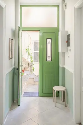 a green door in a hallway with a stool at 1 BD Lycabettus Neoclassic House by Live&Travel in Athens
